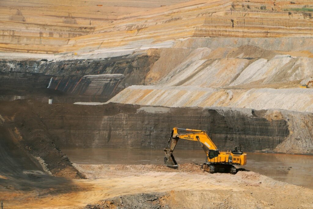 a yellow excavator in a large open pit