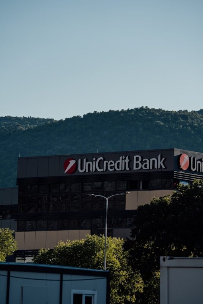 Unicredit bank building with trees and hills