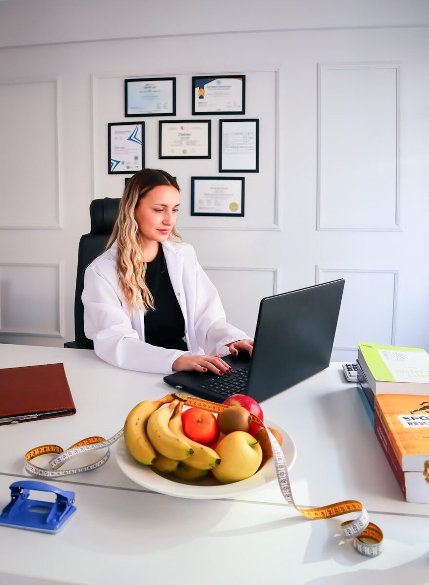 a woman sitting at a desk using a laptop computer