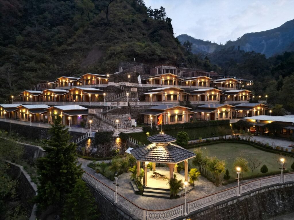 Resort nestled on a mountainside with illuminated buildings.