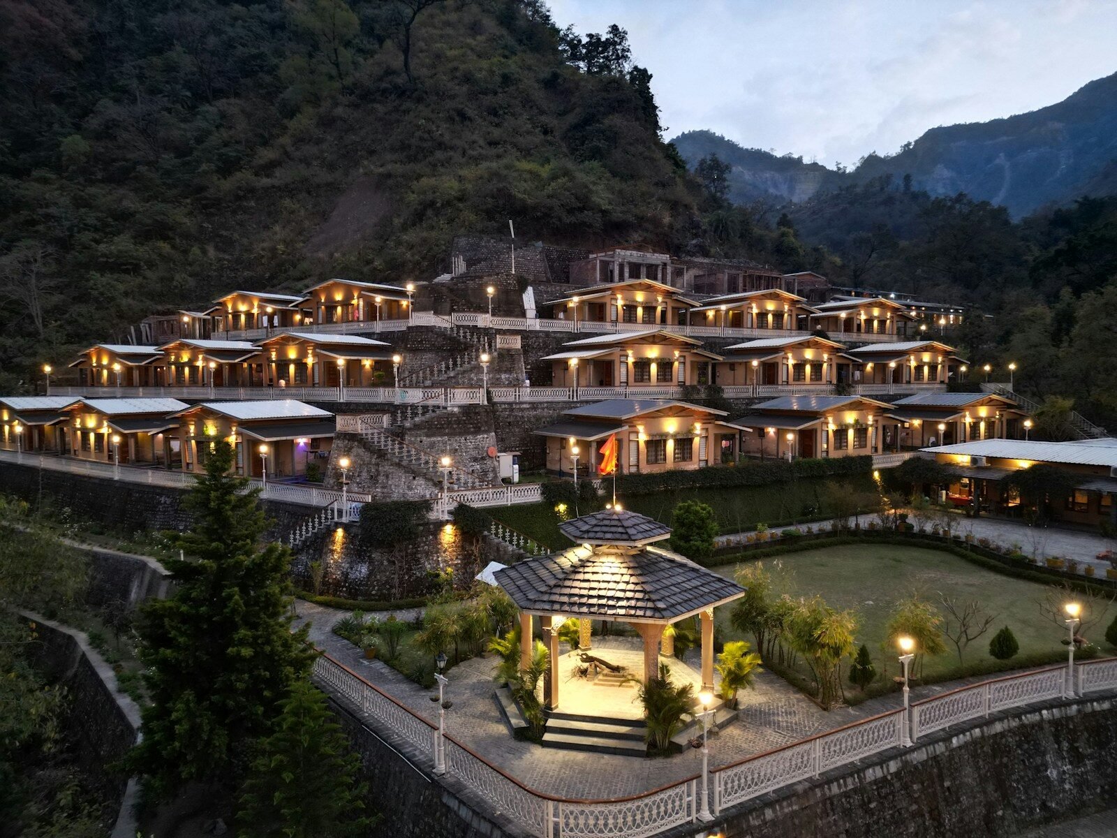 Resort nestled on a mountainside with illuminated buildings.